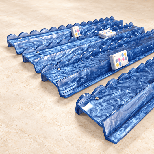 Angled view of four blue marbled acrylic mahjong racks and scalloped pushers on a warm stone surface.