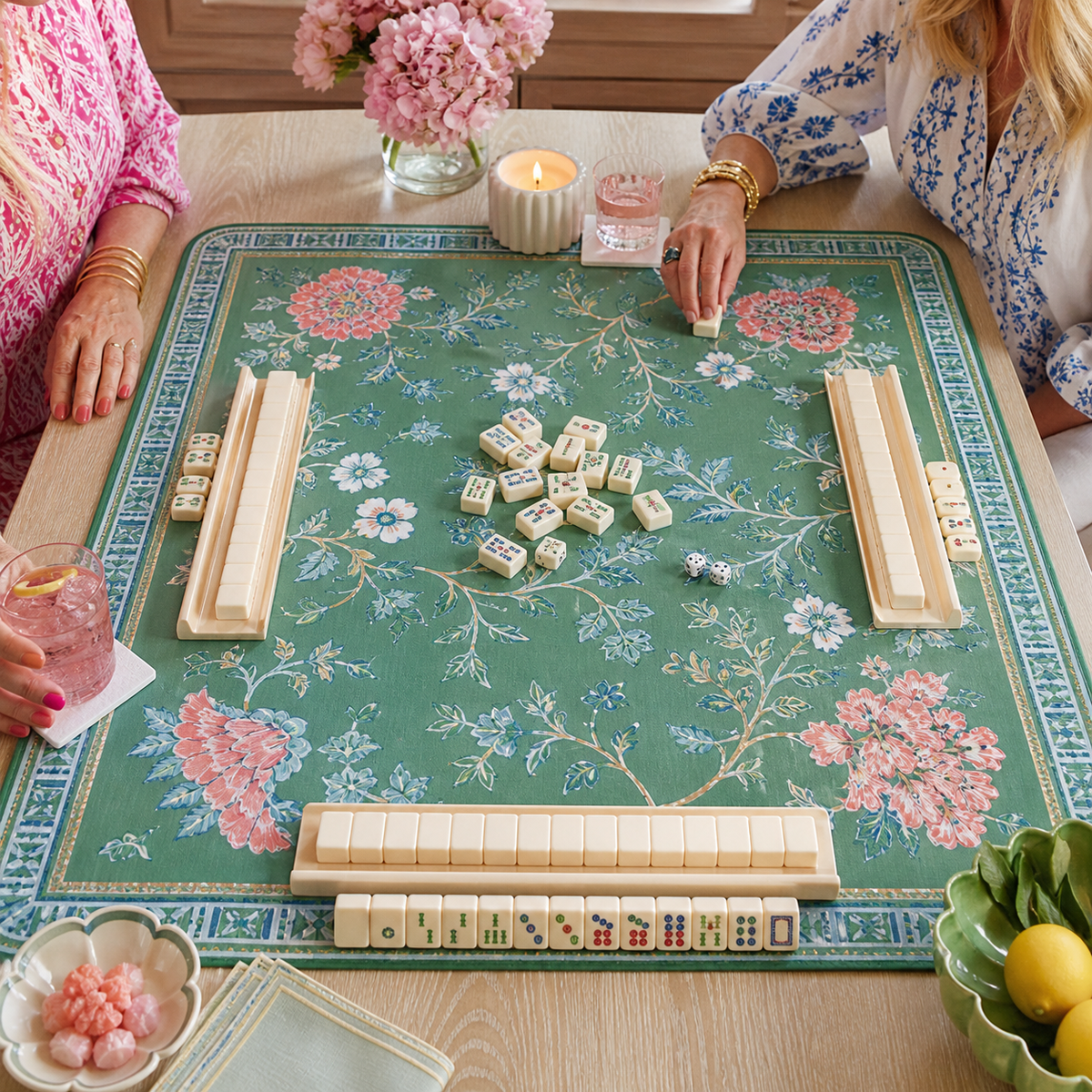 Green floral mahjong mat arranged with tiles and racks for a stylish game night.