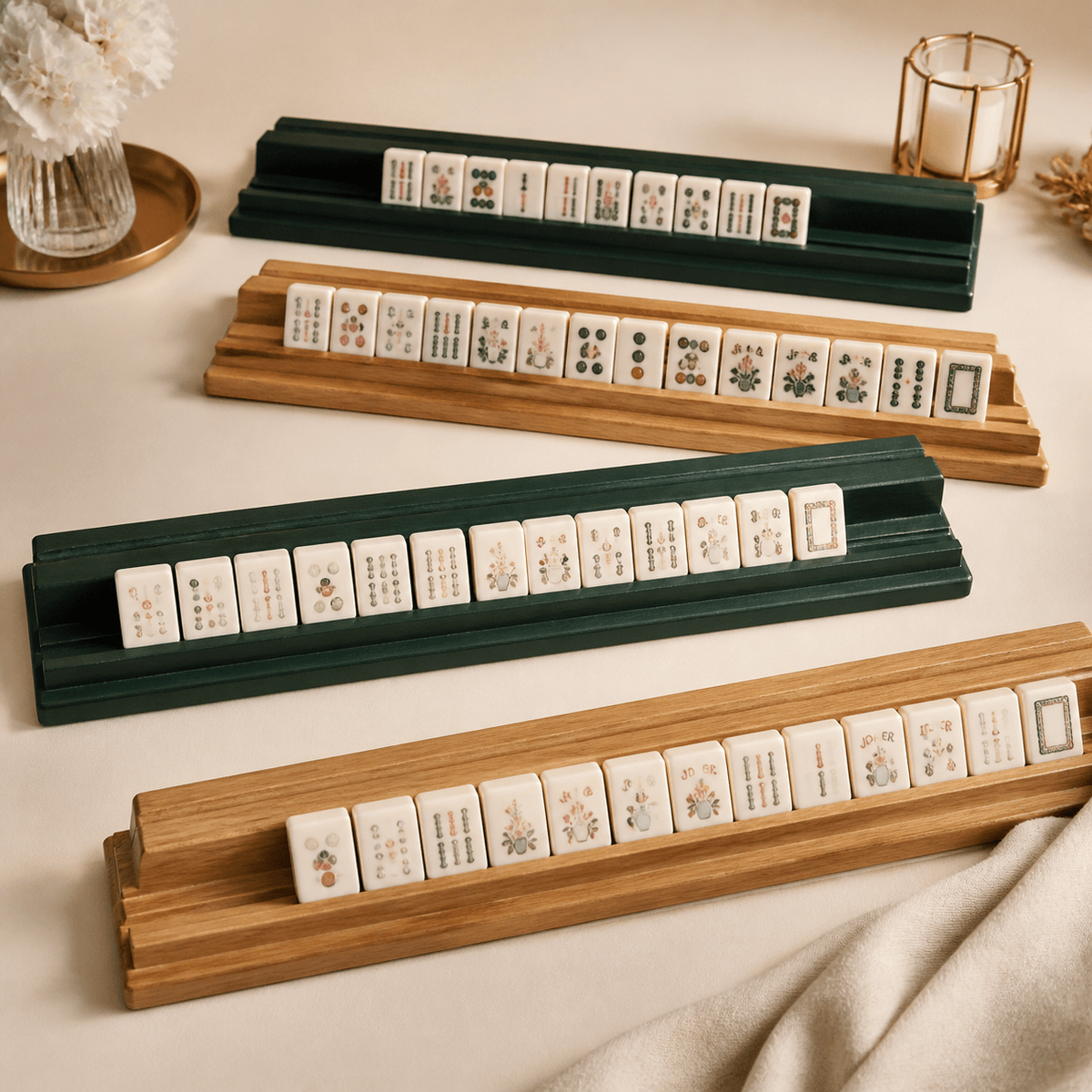 Green mahjong racks displaying floral mahjong tiles in an elegant tabletop setting.