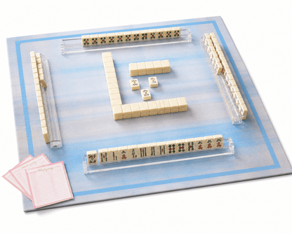 Blue plaid mahjong mat displayed with mahjong tiles, clear racks, dice, and scorecards.