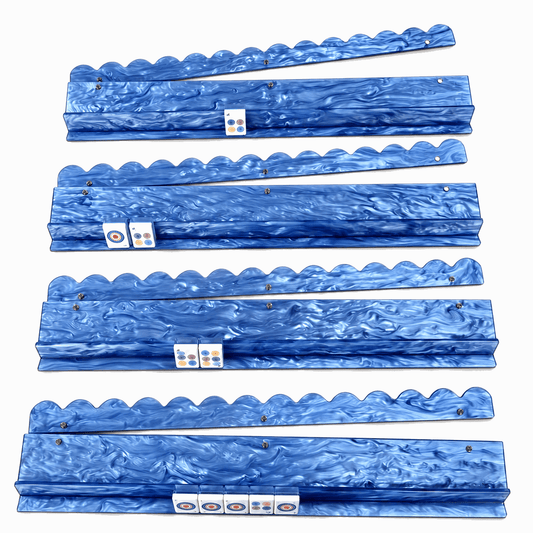 Four blue shell-pattern acrylic mahjong racks with matching scalloped pushers arranged in rows on a light background.
