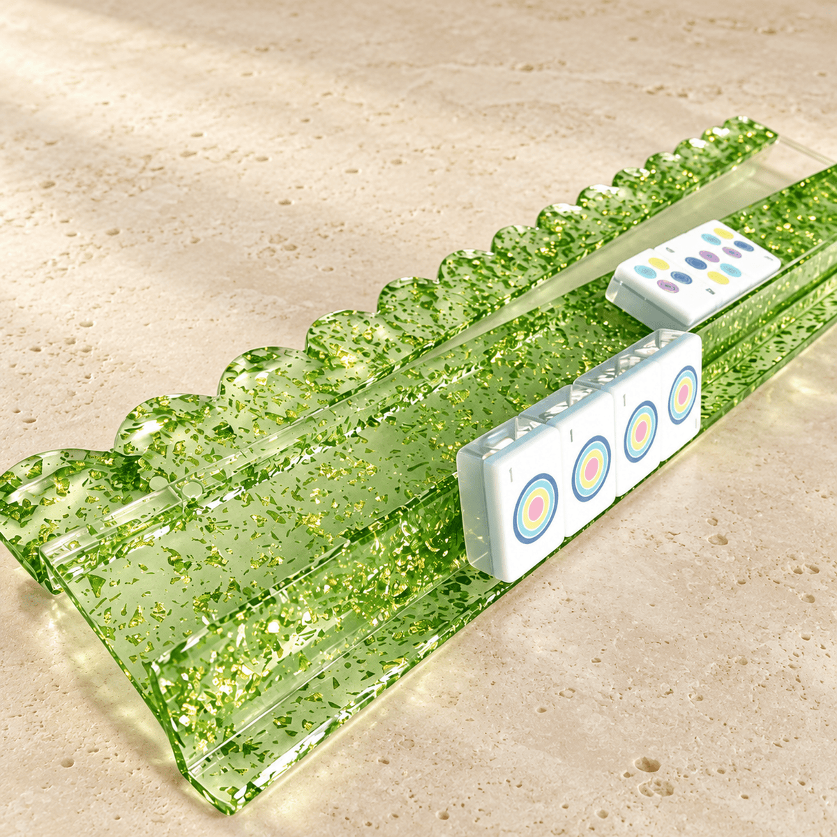 Green gold foil acrylic mahjong rack holding white tiles on a warm stone surface.
