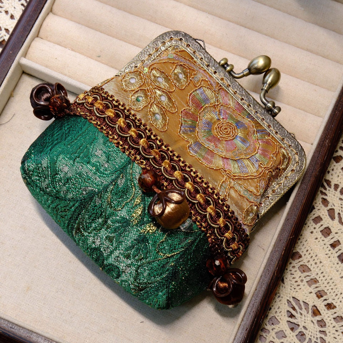 Emerald green coin purse with gold floral embroidery, brass kiss-lock clasp, and bead details.