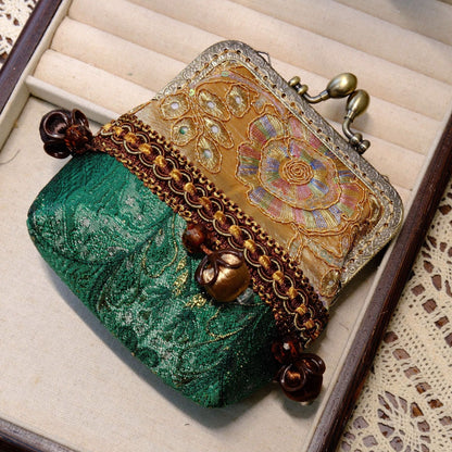 Emerald green coin purse with gold floral embroidery, brass kiss-lock clasp, and bead details.