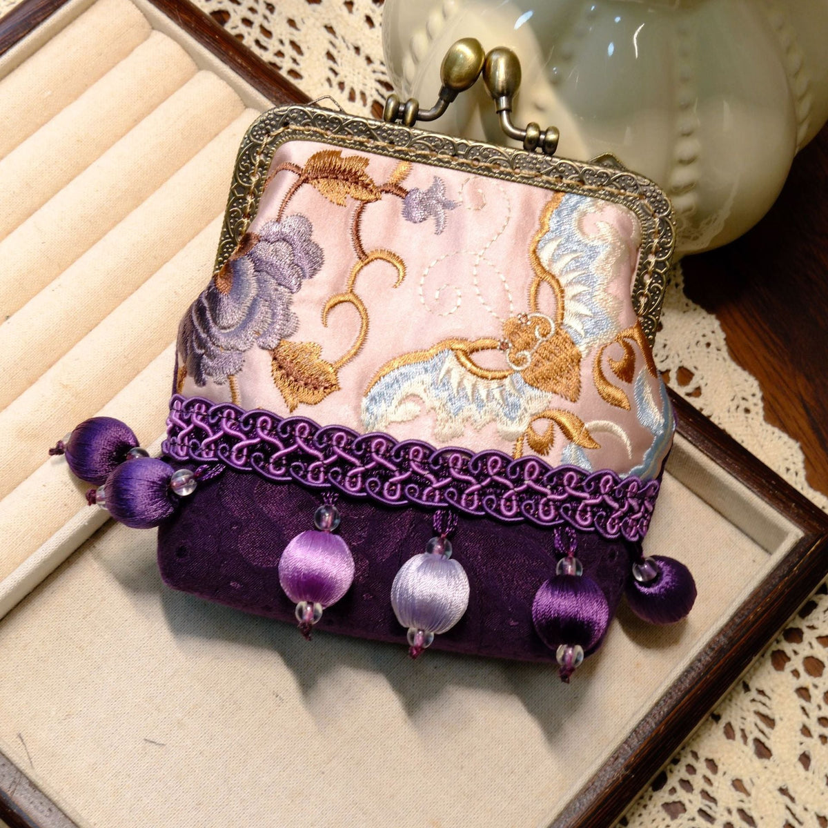 Purple and pale pink embroidered coin purse with a brass clasp and purple bead tassels.