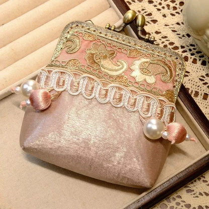 Pink and gold embroidered coin purse with a brass kiss-lock clasp and pearl details.