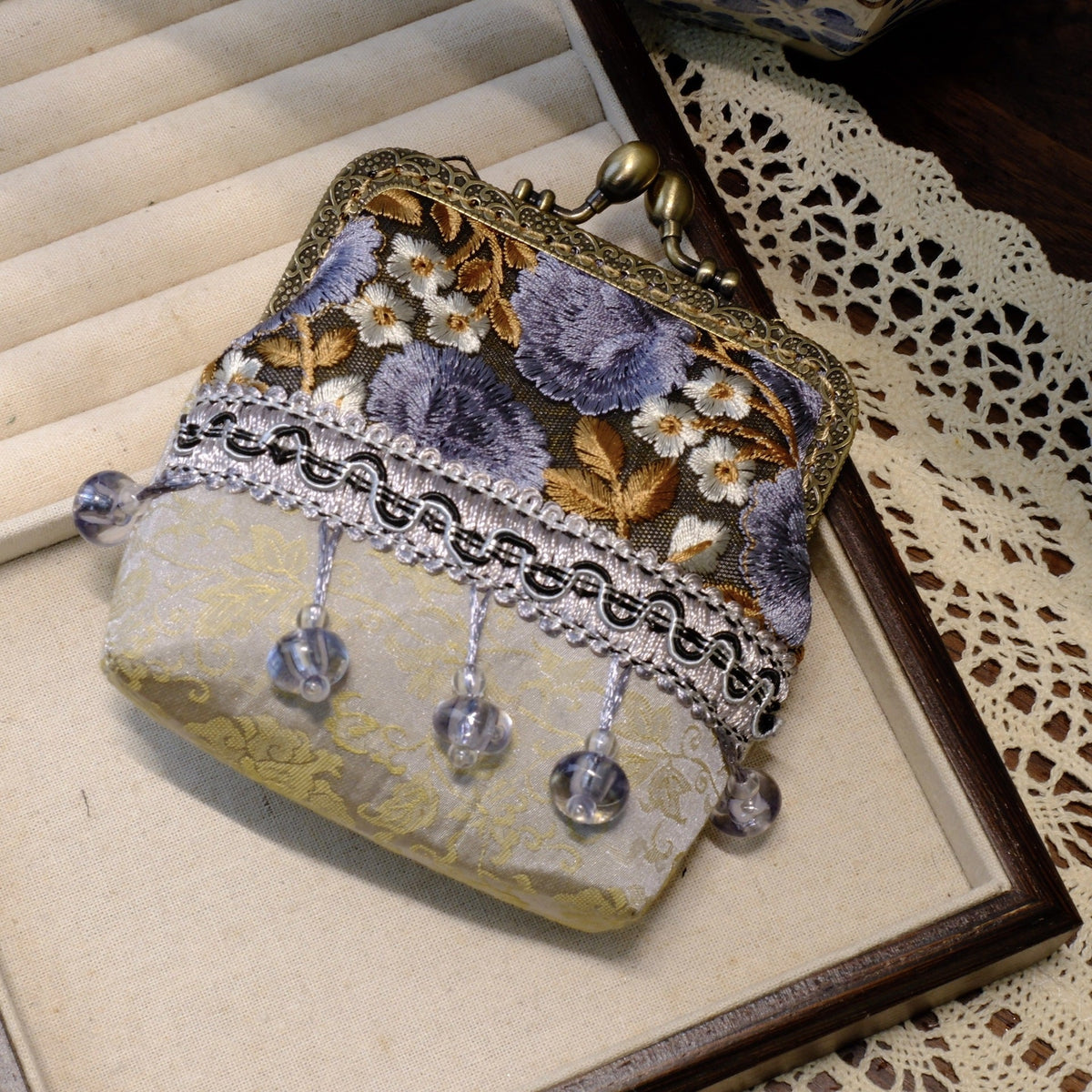 Lavender gray embroidered coin purse with floral detail, brass clasp, and clear bead tassels.