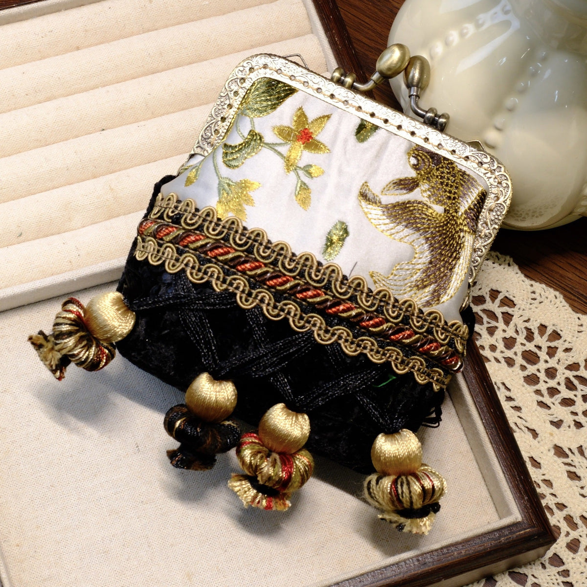 Black and gray vintage coin purse with fish embroidery, brass clasp, and gold tassels.