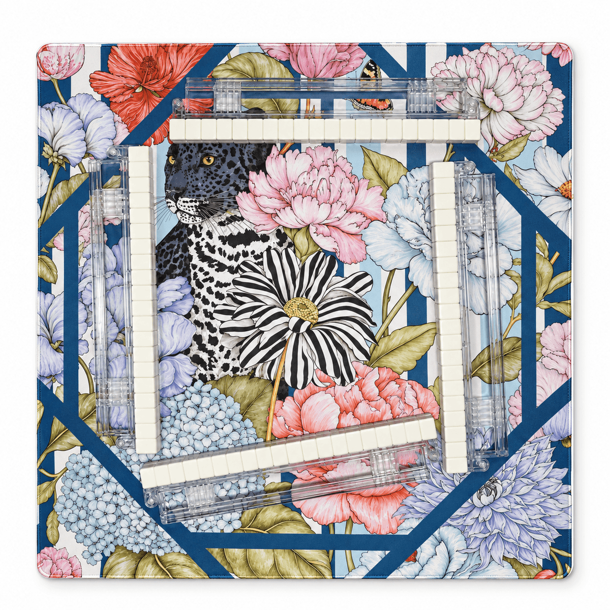 Overhead view of a black leopard floral mahjong mat with four rows of ivory tiles and clear acrylic racks on a white background.