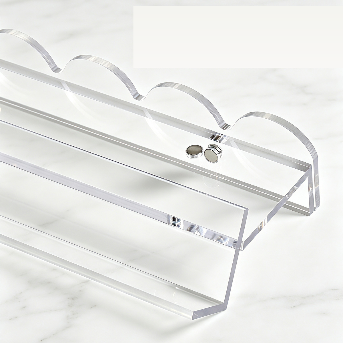 Close-up of a clear mahjong rack and scalloped pusher showing the round attachment points.