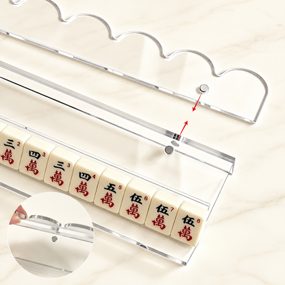 Clear mahjong rack holding tiles with its pusher detached and red arrows indicating the attachment points.