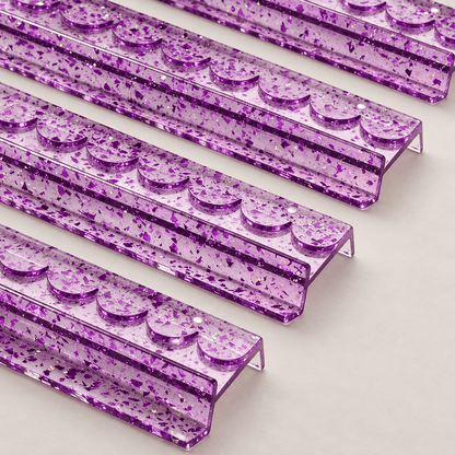 Close-up of four purple acrylic mahjong racks showing scalloped edges and gold foil flecks