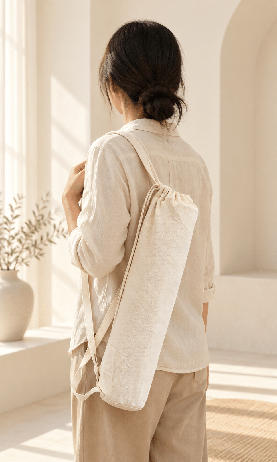 Back view of a person carrying the natural canvas mahjong mat storage bag over one shoulder.